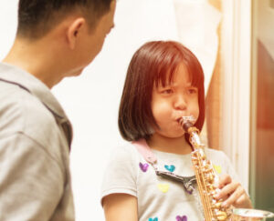 Girl taking saxophone lesson.